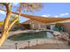 Inviting backyard swimming pool with sunshade, patio, BBQ, lush desert landscaping, and outdoor lighting at 3102 W Louise Dr, Phoenix, AZ 85027