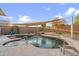 Beautiful backyard swimming pool with a rock waterfall feature, spa, and desert landscaping at 3102 W Louise Dr, Phoenix, AZ 85027