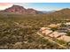 Aerial view of homes nestled in a scenic desert landscape with mountain backdrop at 4330 N Ranier Cir, Mesa, AZ 85215