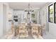 Bright dining room with farmhouse table and chairs, adjacent to kitchen at 4388 N 203Rd Dr, Buckeye, AZ 85396