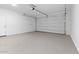 Clean, empty garage with speckled flooring, white walls, and an automatic door, ready for parking at 4388 N 203Rd Dr, Buckeye, AZ 85396