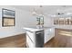 Bright modern kitchen featuring a large island with a stainless steel sink and modern pendant lighting at 4388 N 203Rd Dr, Buckeye, AZ 85396