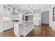 Modern kitchen featuring white cabinets, stainless steel appliances, and a large center island with quartz countertops at 4388 N 203Rd Dr, Buckeye, AZ 85396