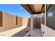 Covered patio with concrete flooring and a backyard block wall providing privacy, merging indoor-outdoor living at 4388 N 203Rd Dr, Buckeye, AZ 85396