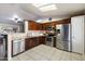 Well-lit kitchen showcasing dark wood cabinetry, stainless steel appliances, and tile flooring at 480 E Bart Dr, Chandler, AZ 85225