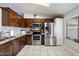 Traditional kitchen featuring wood cabinets, stainless steel appliances, and tile flooring at 480 E Bart Dr, Chandler, AZ 85225