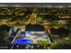 Night aerial view of home with a backyard pool, deck, and lush green lawn at 5344 E Catalina Ave, Mesa, AZ 85206