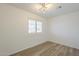 Bright bedroom featuring stylish light fixture, wood floors, and plantation shutters at 5344 E Catalina Ave, Mesa, AZ 85206