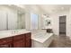 Elegant bathroom with double sinks, soaking tub, and walk-in shower at 5612 W Alyssa Ln, Phoenix, AZ 85083