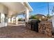 Covered outdoor kitchen with a built-in grill and stone accents at 6809 E Gelding Dr, Scottsdale, AZ 85254