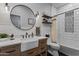 Stylish bathroom featuring white subway tile, a round mirror, farmhouse sink, and a shower with patterned curtain at 8171 W Beaubien Dr, Peoria, AZ 85382