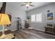 Bright bedroom with wood floors, ceiling fan, a desk with a lamp, and coastal-themed decor accents at 8171 W Beaubien Dr, Peoria, AZ 85382