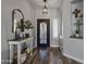 Inviting foyer with wood floors, decorative mirror, and a black metal door and light fixture at 8171 W Beaubien Dr, Peoria, AZ 85382