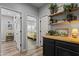 Hallway featuring wood floors, neutral walls, open doorways, and floating shelves with decorative plants and pottery at 8171 W Beaubien Dr, Peoria, AZ 85382