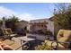 A backyard sitting area featuring comfortable chairs around an outdoor fireplace at 8171 W Beaubien Dr, Peoria, AZ 85382