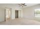 Bright bedroom features neutral carpet, a ceiling fan, a large window, and mirrored closets at 9705 E Mountain View Rd # 1050, Scottsdale, AZ 85258