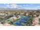 Aerial view of community featuring tennis courts and residential buildings against a mountain backdrop at 9705 E Mountain View Rd # 1050, Scottsdale, AZ 85258