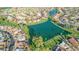 Scenic aerial view of a community showcasing a lake, green spaces, and residential homes at 9725 E Navajo Pl, Sun Lakes, AZ 85248