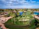 Aerial view showcasing the golf course with water features and trees, integrated within the residential community at 9725 E Navajo Pl, Sun Lakes, AZ 85248