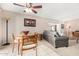 Bright dining area with a ceiling fan, access to the patio, and adjacent living room at 9725 E Navajo Pl, Sun Lakes, AZ 85248