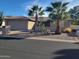 Charming home featuring desert landscaping with mature palm trees and a two-car garage at 9725 E Navajo Pl, Sun Lakes, AZ 85248