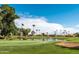 A picturesque view of the golf course showcasing a water hazard with a fountain and mature landscaping at 9725 E Navajo Pl, Sun Lakes, AZ 85248