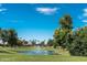 A picturesque view of the community golf course featuring a water hazard with a fountain and lush green landscaping at 9725 E Navajo Pl, Sun Lakes, AZ 85248