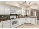 Well-lit kitchen featuring white appliances, mosaic backsplash, and tiled countertops at 9725 E Navajo Pl, Sun Lakes, AZ 85248