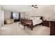 Bright bedroom with dark wood furnishings, ceiling fan, and neutral carpeting at 9725 E Navajo Pl, Sun Lakes, AZ 85248