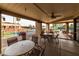 Outdoor patio area featuring tables, chairs, ceiling fan, and views of the community tennis courts at 9725 E Navajo Pl, Sun Lakes, AZ 85248