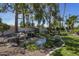 Landscaped backyard with a beautiful rock waterfall feature and lush greenery at 10685 E Cinnabar Ave, Scottsdale, AZ 85258