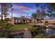 Tranquil backyard with a pond, landscaped greenery, a lush lawn, and a fire pit at 10685 E Cinnabar Ave, Scottsdale, AZ 85258