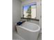 Bright bathroom featuring a modern soaking tub and views of the backyard at 10685 E Cinnabar Ave, Scottsdale, AZ 85258