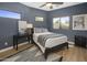 Bedroom with blue walls, stylish decor, and natural light from multiple windows at 10685 E Cinnabar Ave, Scottsdale, AZ 85258