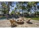 Inviting outdoor fire pit area surrounded by mature trees and a custom pool at 10685 E Cinnabar Ave, Scottsdale, AZ 85258