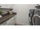 Neat laundry room with gray counter, white cabinetry, and modern washer and dryer at 10685 E Cinnabar Ave, Scottsdale, AZ 85258