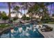 Beautiful pool area with rock features, lush landscaping, and comfortable seating, perfect for relaxation at 10685 E Cinnabar Ave, Scottsdale, AZ 85258