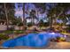 Inviting pool area with rock features, lounge chairs, and lush landscaping at 10685 E Cinnabar Ave, Scottsdale, AZ 85258