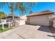 Beige stucco home featuring a two-car garage, and a well-maintained yard with mature trees and bushes at 11129 N 109Th St, Scottsdale, AZ 85259