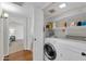 This compact laundry room features a washer and dryer and plenty of shelving for storage at 11129 N 109Th St, Scottsdale, AZ 85259