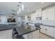 Modern kitchen with white cabinets, granite island, and stainless steel appliances at 13184 N 144Th Ln, Surprise, AZ 85379