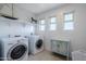 Laundry room with washer, dryer, and storage cabinet at 13184 N 144Th Ln, Surprise, AZ 85379