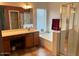 Bathroom with soaking tub, shower, and wood cabinets at 14960 W Cottonwood St, Surprise, AZ 85374