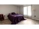 Simple bedroom with a purple comforter and wood-look floors at 16033 N 110Th Ave, Sun City, AZ 85351