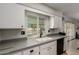 Kitchen with white cabinets, gray countertops, and a backyard view at 16033 N 110Th Ave, Sun City, AZ 85351