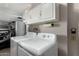 Bright laundry room with washer, dryer, and overhead cabinets at 16033 N 110Th Ave, Sun City, AZ 85351