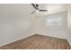 Bright, minimalist bedroom features wood-look floors, white walls, ceiling fan, and a window at 1702 W Tuckey Ln # 123, Phoenix, AZ 85015