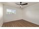 Minimalist bedroom features wood-look floors, white walls, and a ceiling fan at 1702 W Tuckey Ln # 123, Phoenix, AZ 85015