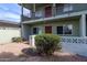 Two-story condo with rock landscaping and a large bush, showing the entryway at 1702 W Tuckey Ln # 123, Phoenix, AZ 85015