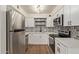 Clean kitchen featuring white cabinets, stainless steel appliances, and decorative backsplash at 1702 W Tuckey Ln # 123, Phoenix, AZ 85015